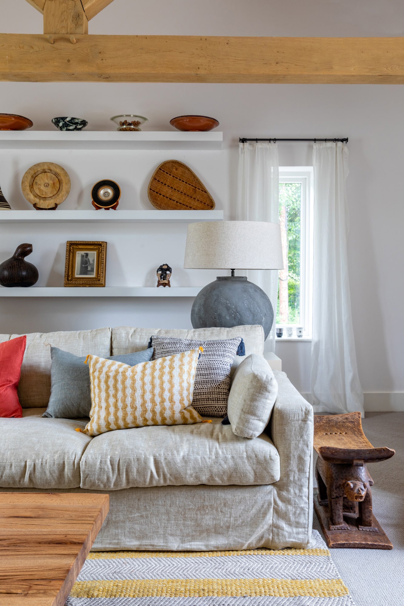 Interior photography: living room detail, a grey sofa with pillows; white shelves with cute accessories