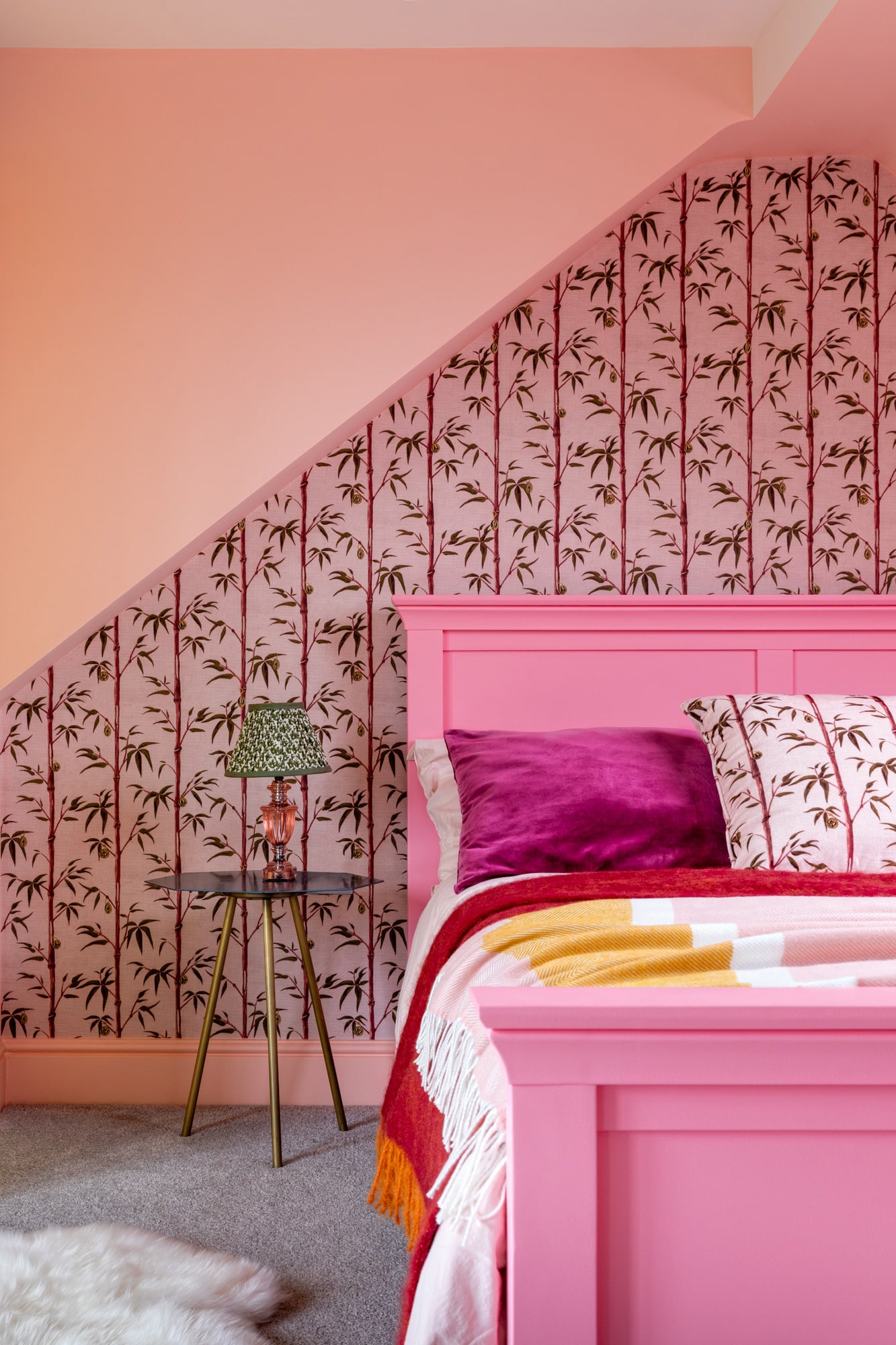 pink girl's bedroom: pink bed, floral wallpapers feature walls, glass bedside table