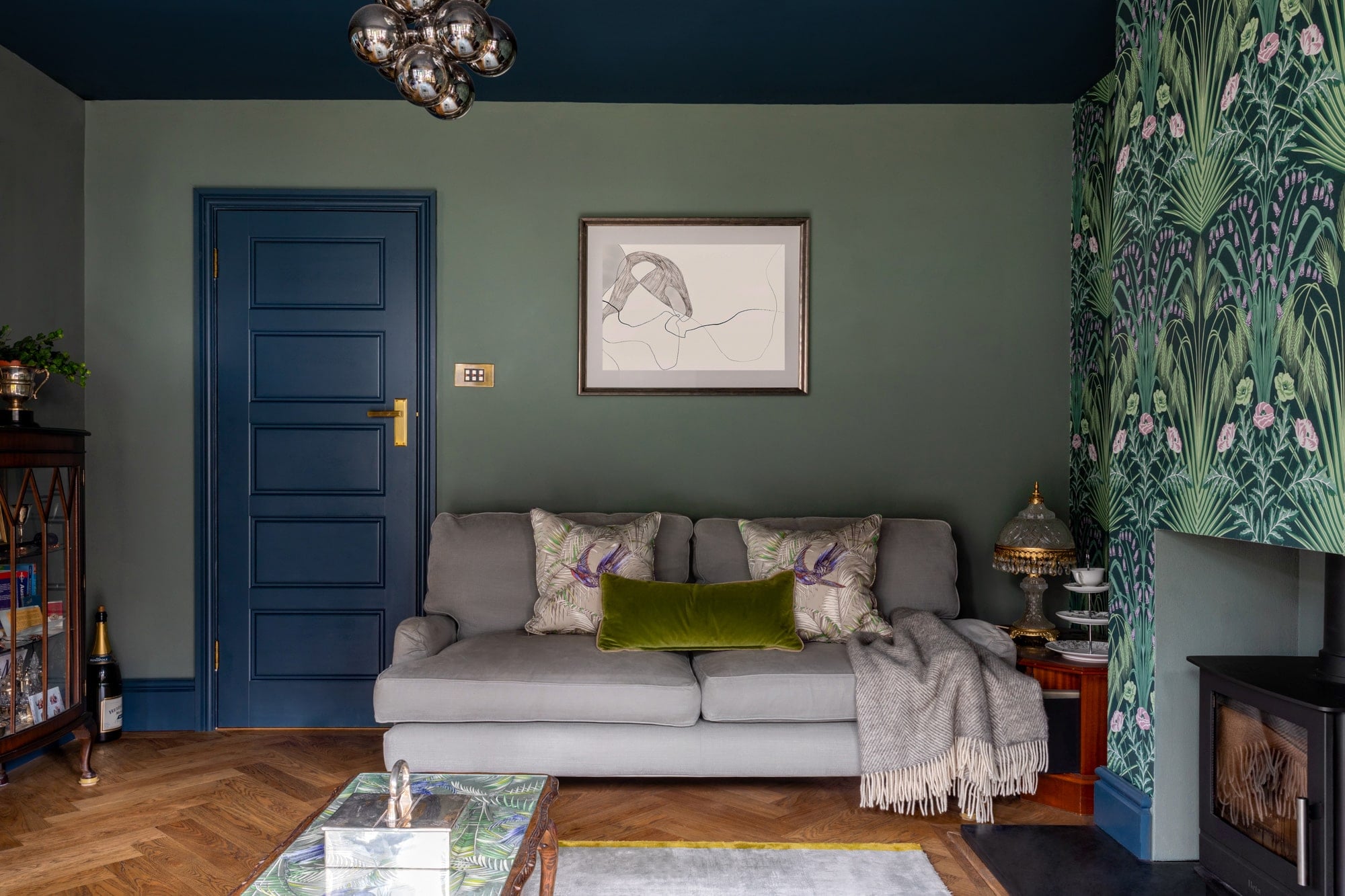 Sitting room with eclectic vibrant wallpaper, fireplace, blue and green colour scheme