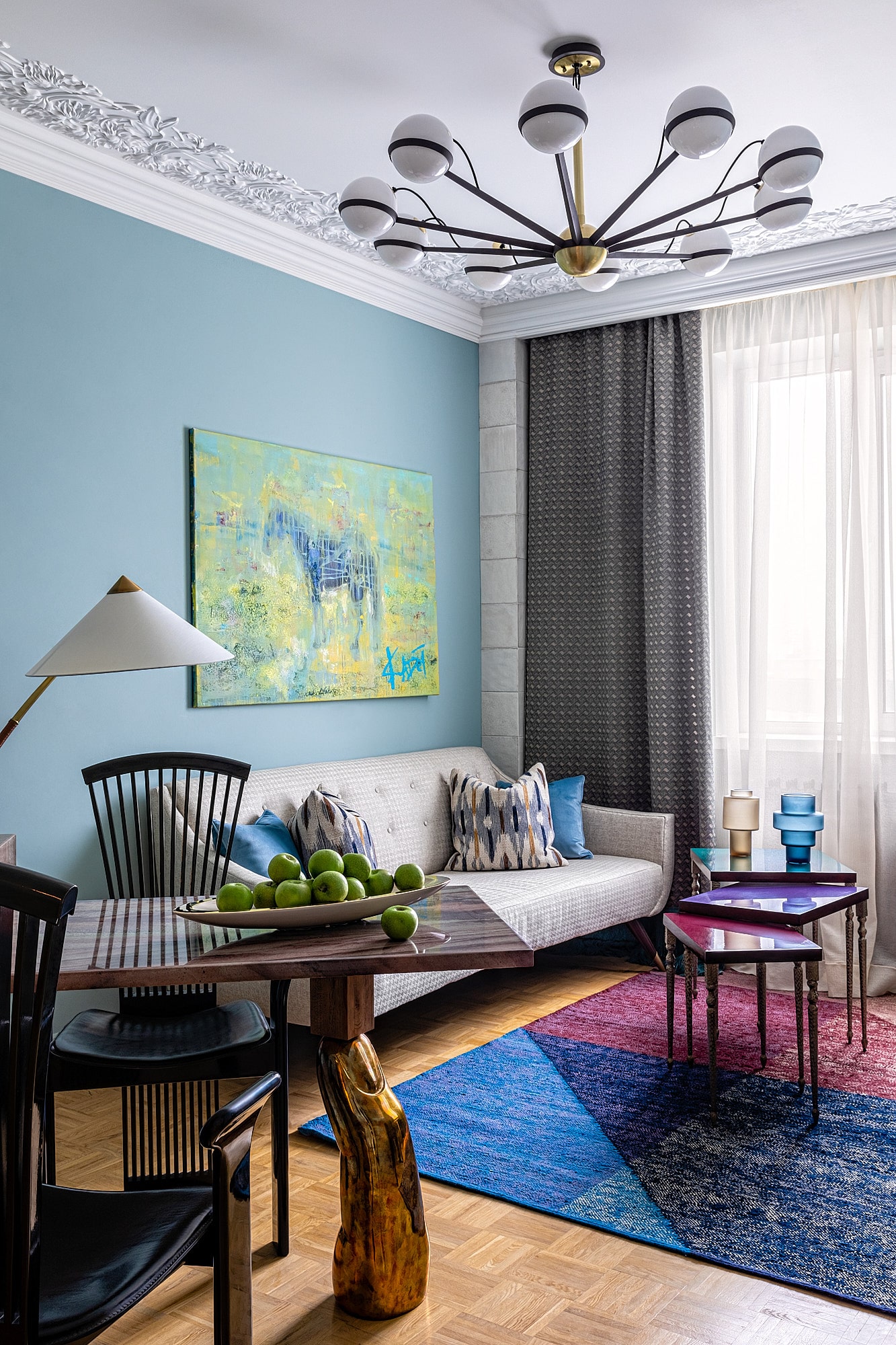 Living room with blue walls, art and colourful rug