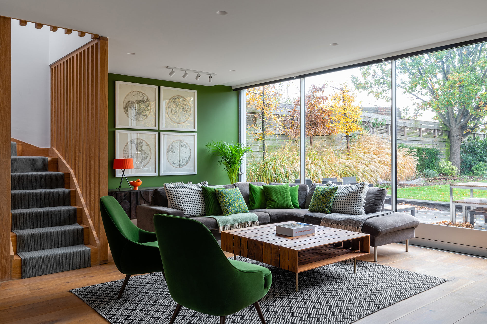 living room with a green wall and big grey sofa