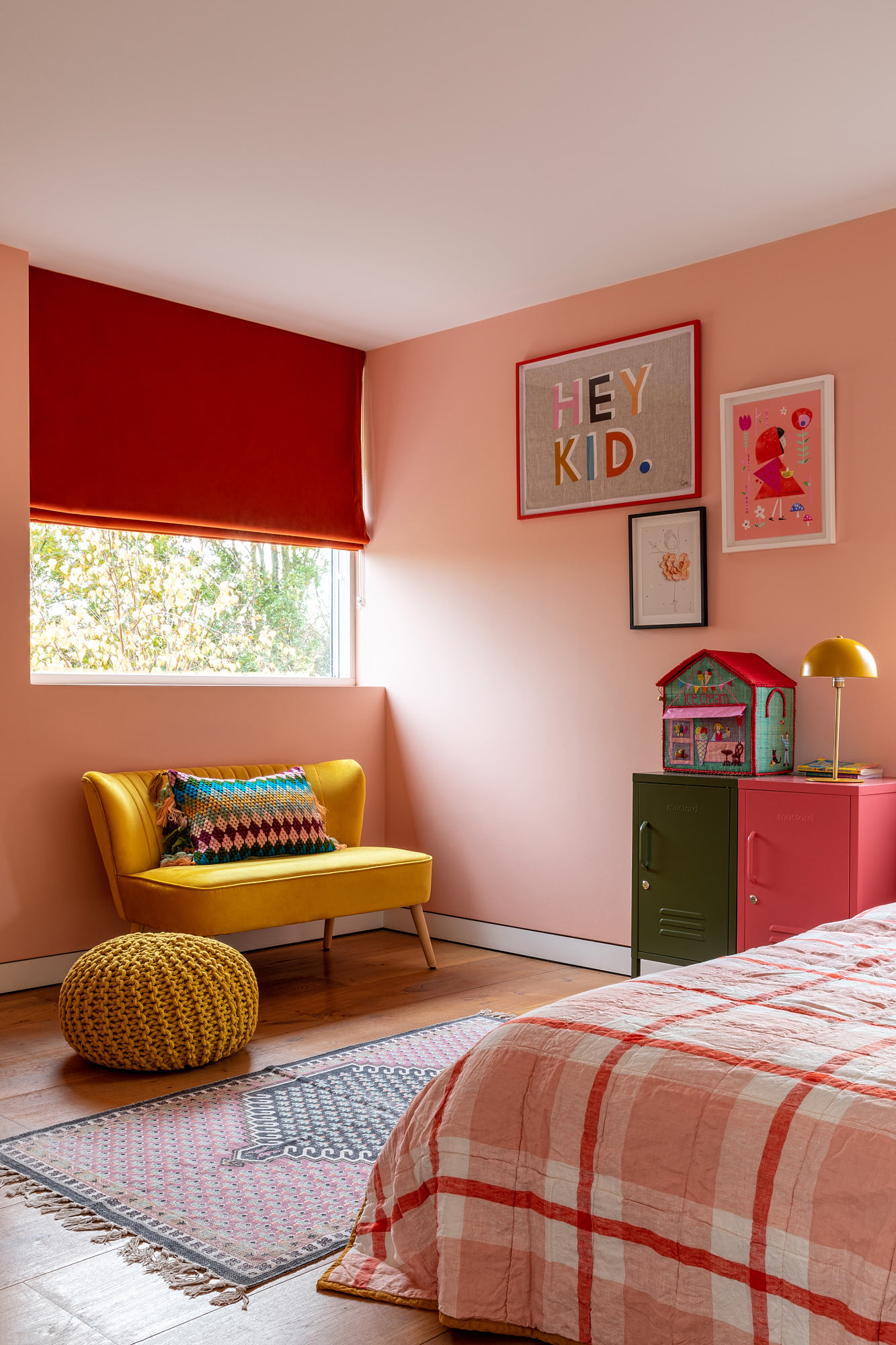 girls bedroom with warm bright pink walls, yellow sofa