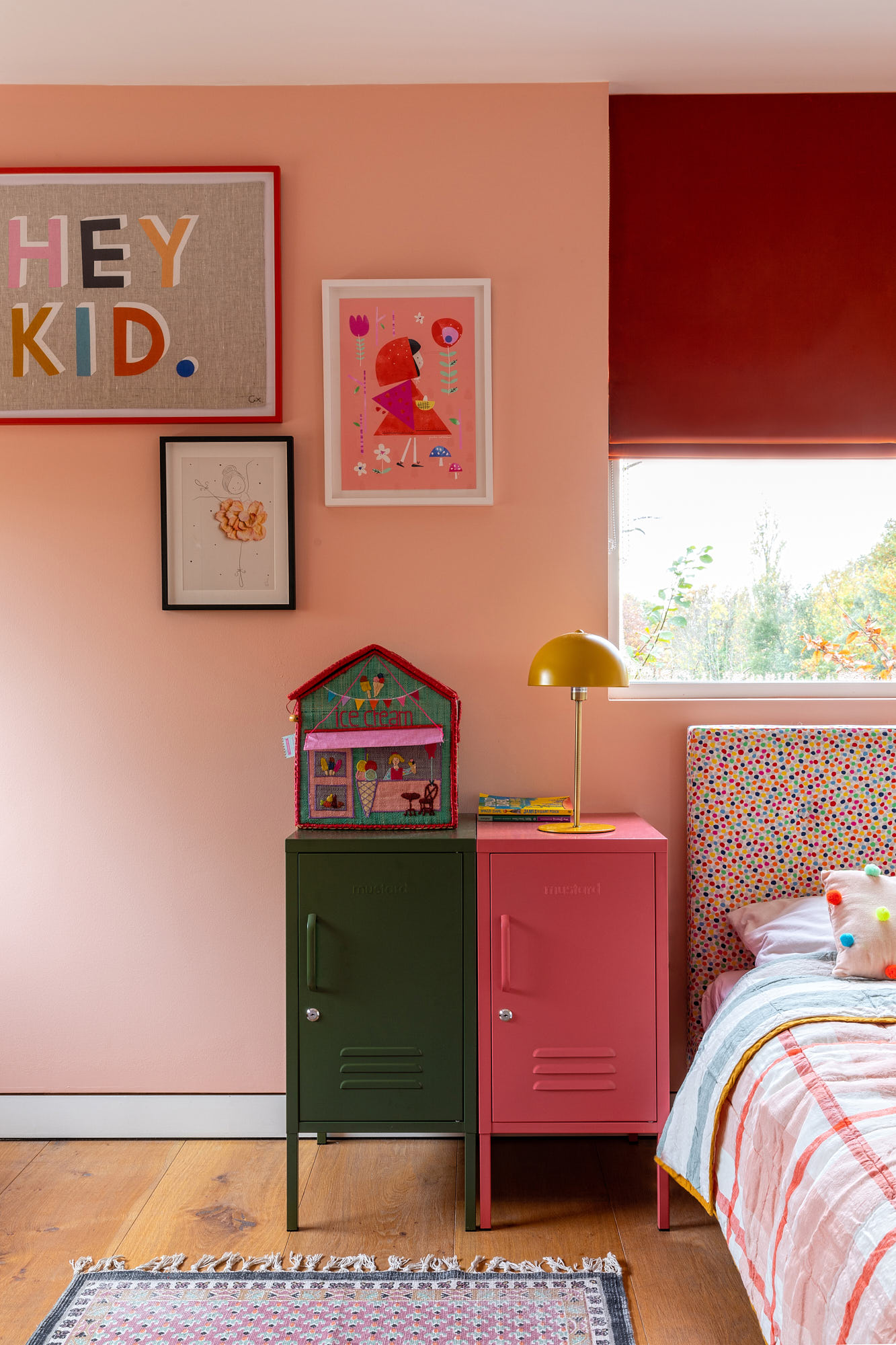 girl's bedroom with pink wall, posters, bed 