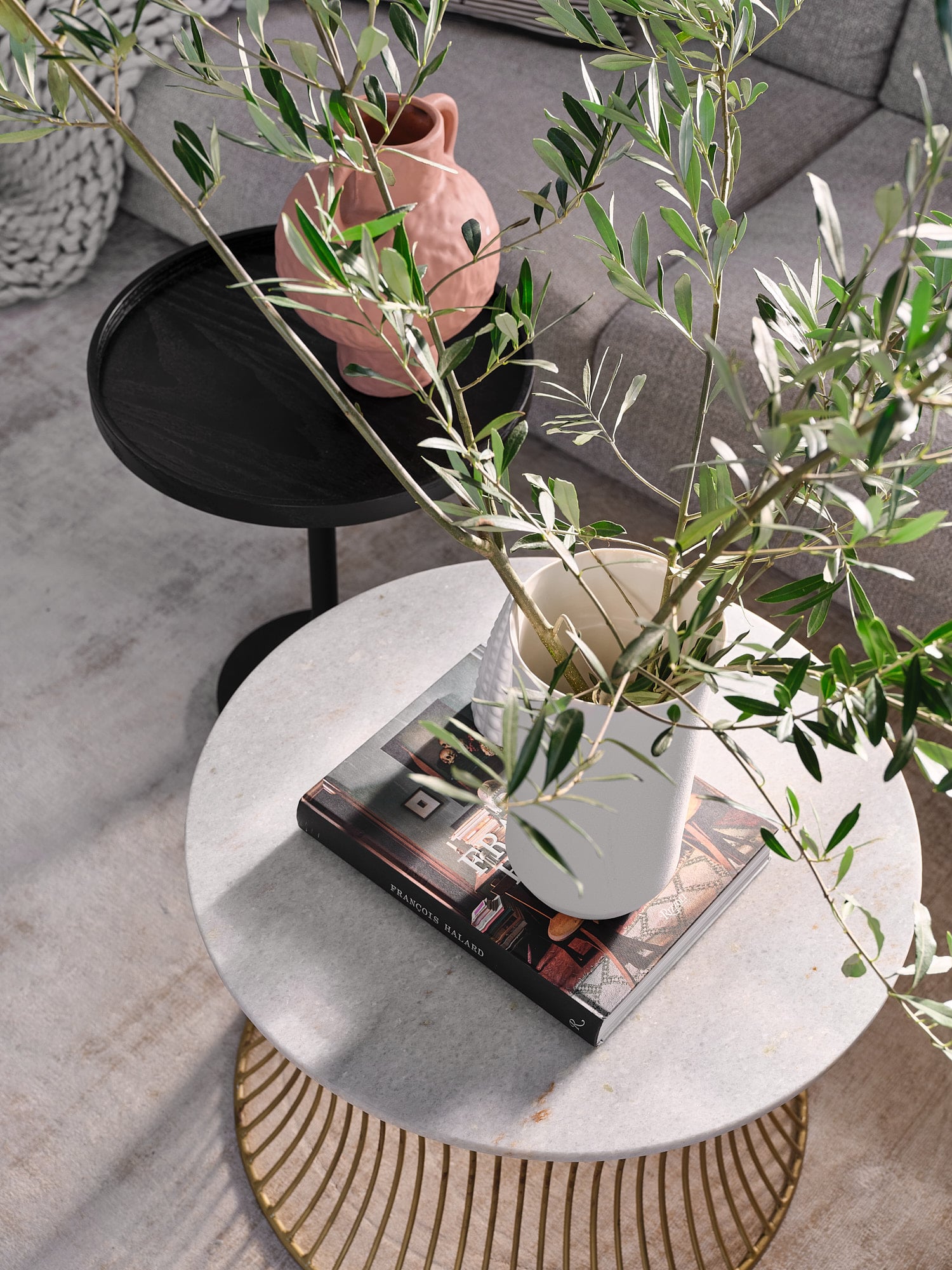 detail shot of a round coffee table with a vase and book on it